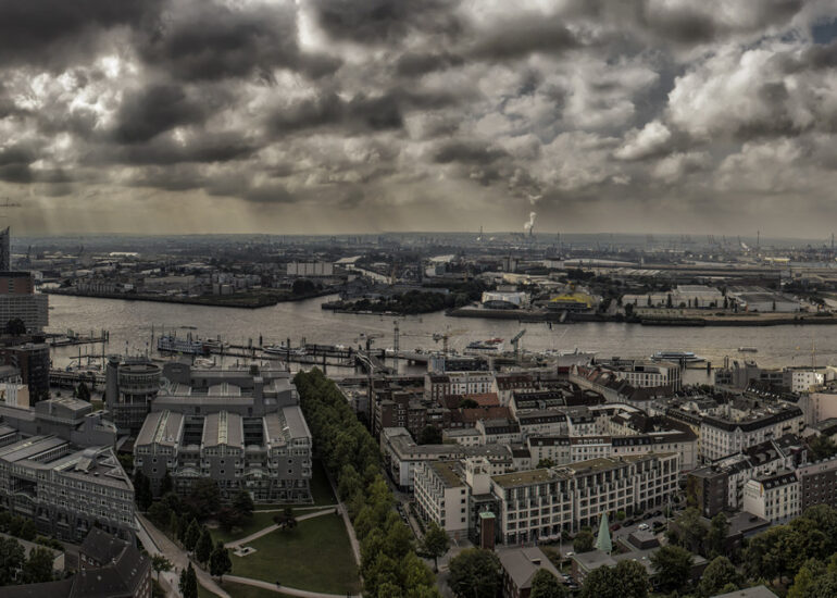Panoramablick auf die Stadt Hamburg mit der Elbe, markanten Gebäuden und dramatischen Wolkenformationen