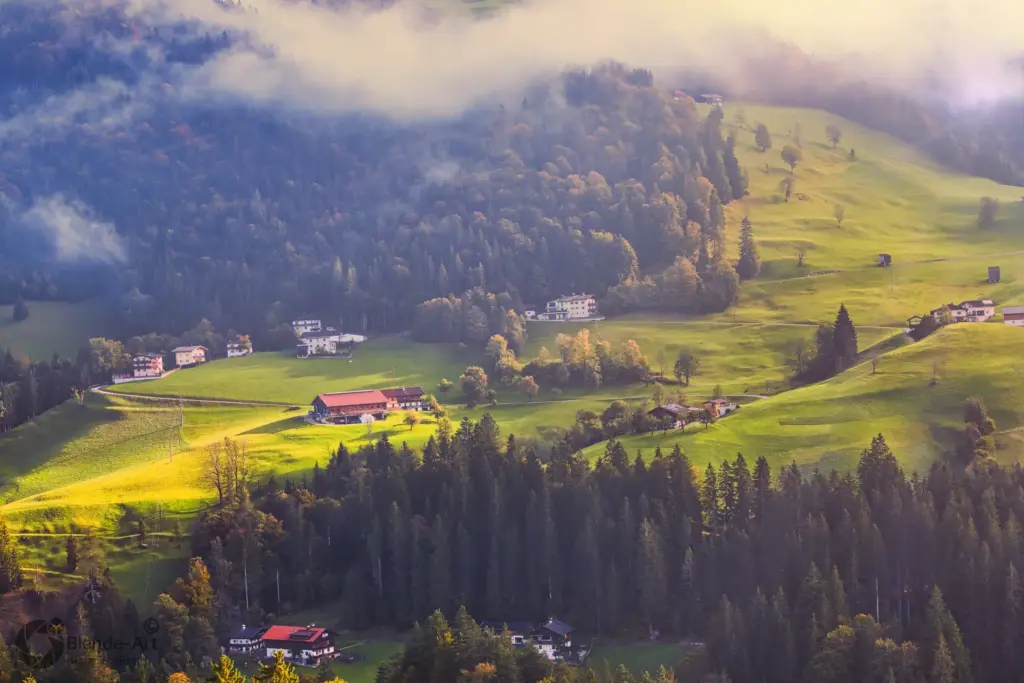 Berglandschaft in Tirol mit Almwiesen, verstreuten Häusern und aufsteigendem Nebel im weichen Morgenlicht, im Umkreis von Pertisau
