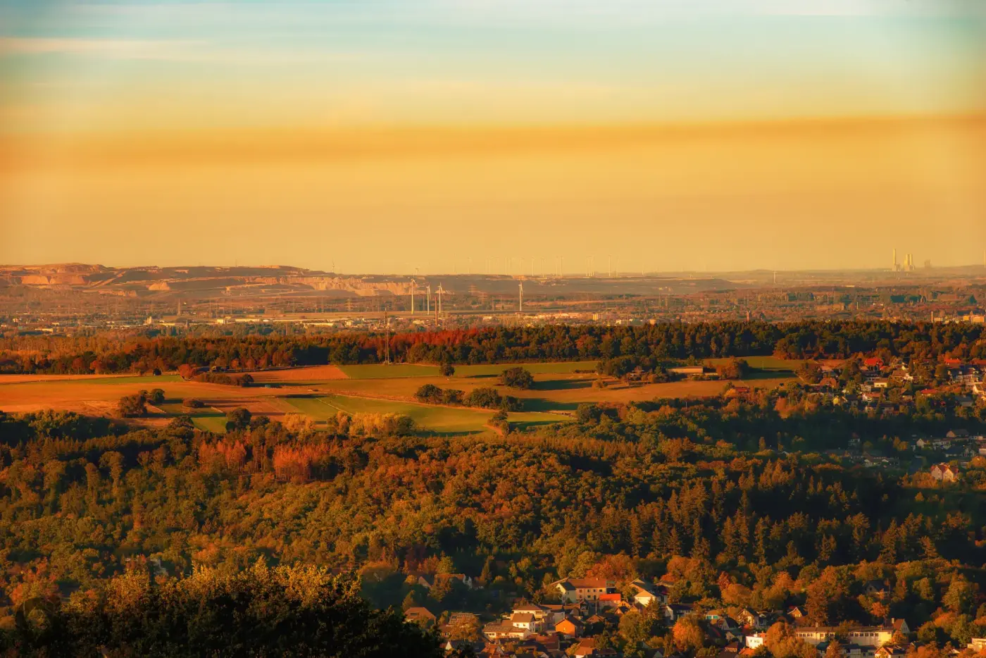 Blick über die waldreiche Umgebung von Aachen auf das rheinische Braunkohlerevier mit Tagebau im Abendlicht