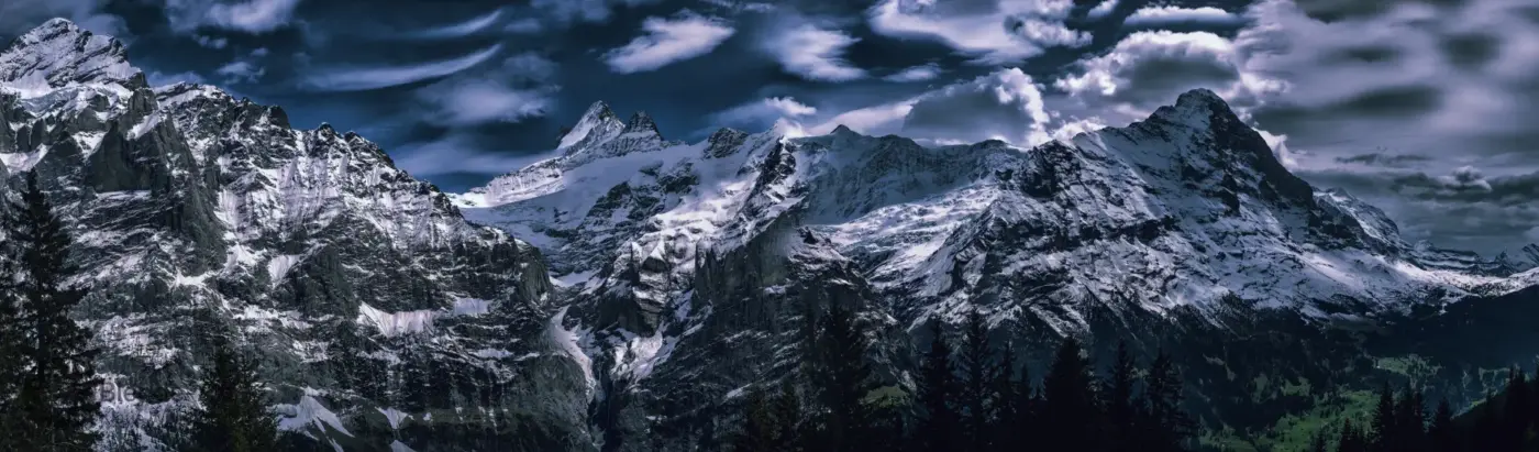 Panorama der schneebedeckten Schweizer Alpen mit Eiger, Mönch und Jungfrau bei dramatischer Wolkenstimmung