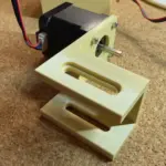 3D-gedruckte NEMA-17 Halterung mit montiertem Schrittmotor und sichtbarer Welle auf einer Werkbank