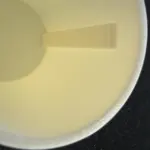 Detailansicht eines weißen 3D-gedruckten Messbechers mit integrierter 100-ml-Innenskalierung aus ASA