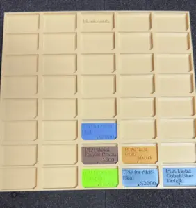 Filament-Muster-Tafel mit eingeklickten Filament-Plättchen verschiedener Farben und Materialien