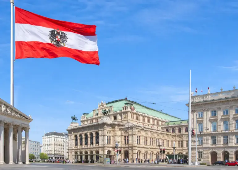 Wien Staatsoper und Parlament mit österreichischer Flagge vor blauem Himmel