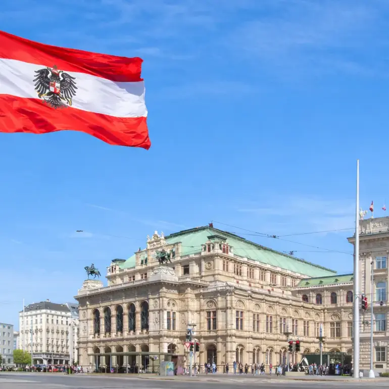 Wien Staatsoper und Parlament mit österreichischer Flagge vor blauem Himmel