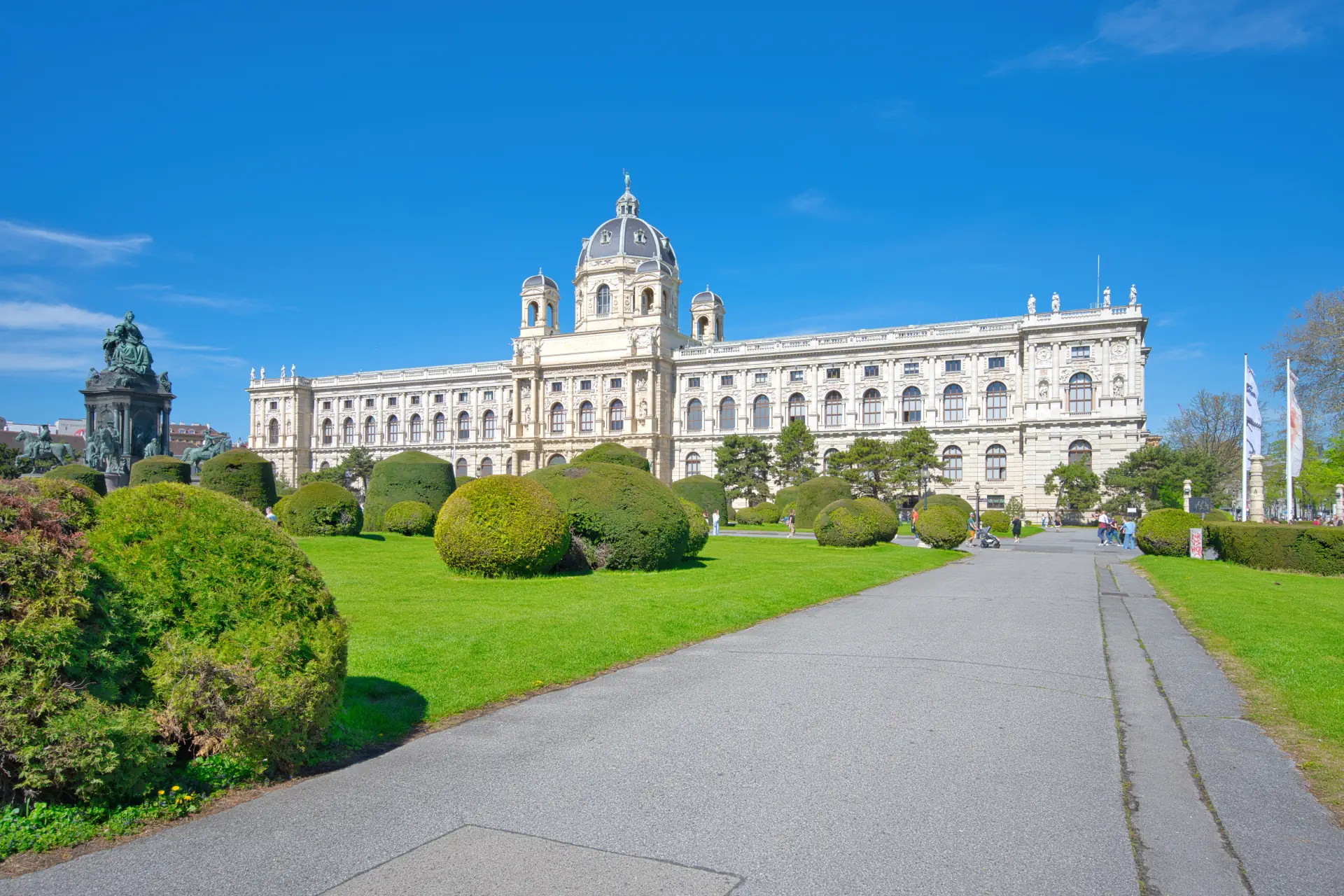 Panorama des Naturhistorischen Museums in Wien mit seiner monumentalen Fassade im Stil der Neorenaissance und herrschaftlichem Vorplatz unter blauem Himmel.