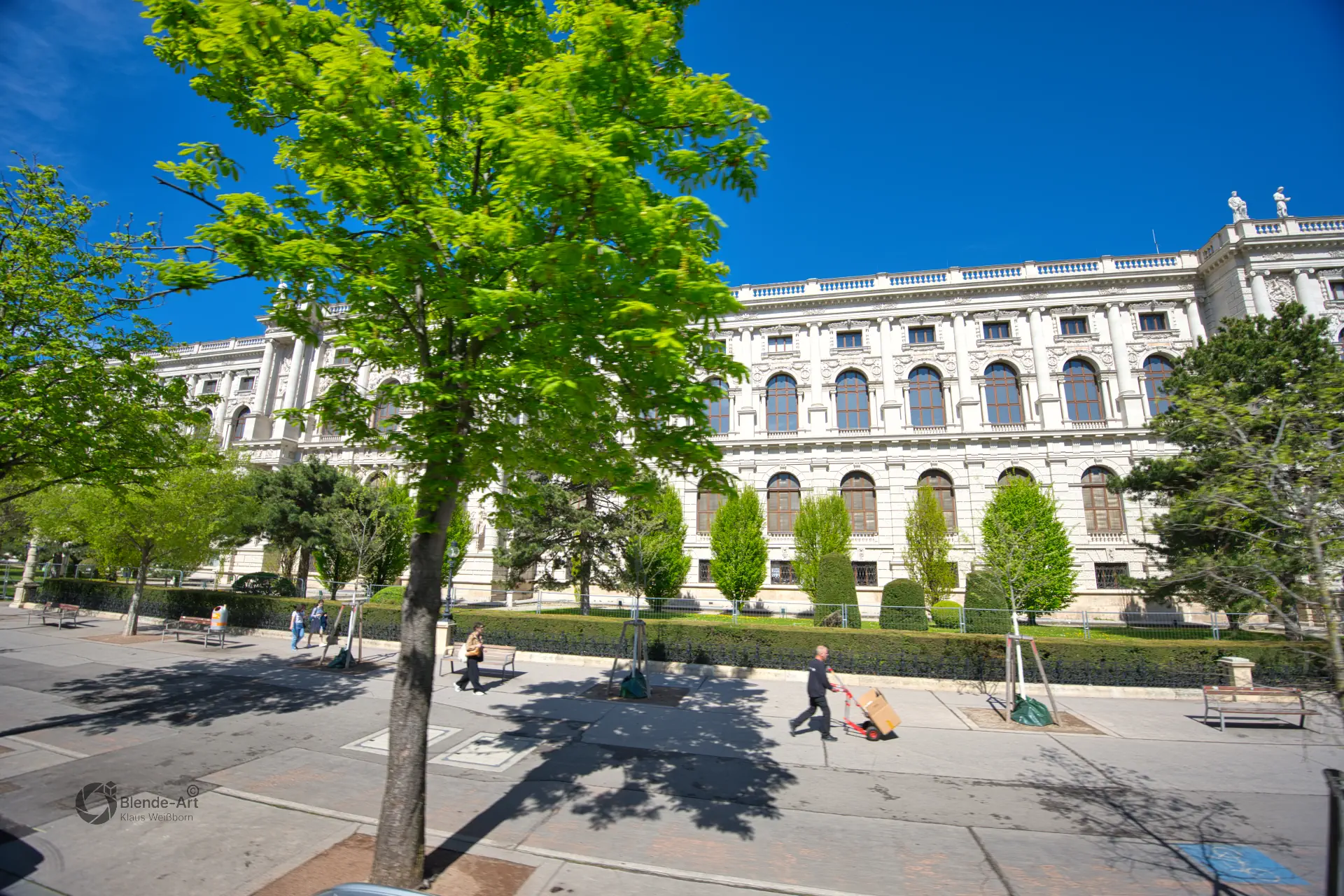 Panorama des Naturhistorischen Museums in Wien mit seiner monumentalen Fassade im Stil der Neorenaissance und herrschaftlichem Vorplatz unter blauem Himmel.
