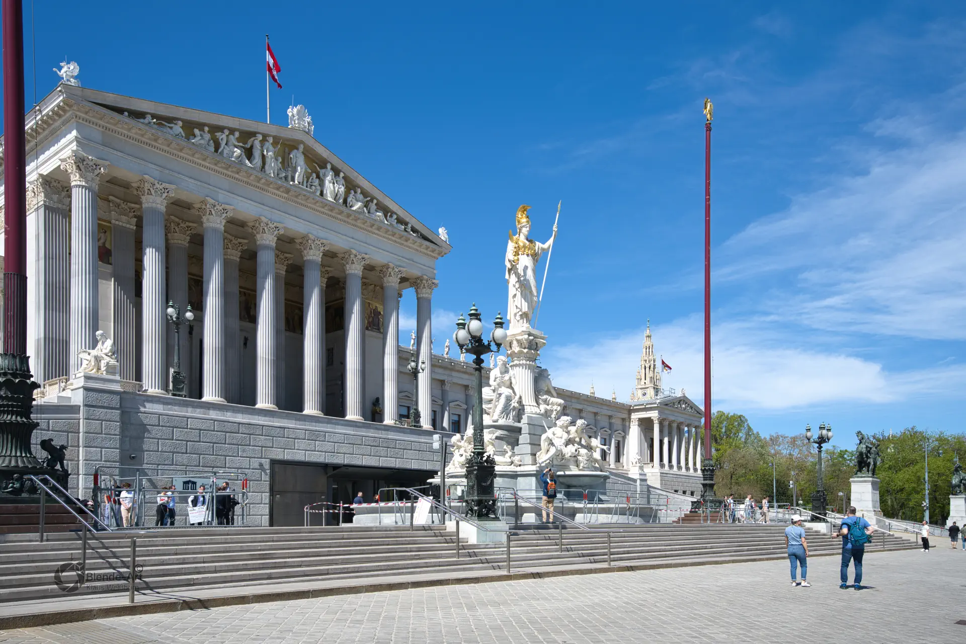 Blick über den Vorplatz auf das Wiener Parlamentsgebäude mit dem markanten Pallas-Athene-Brunnen und dem Säulenportal im griechischen Stil.