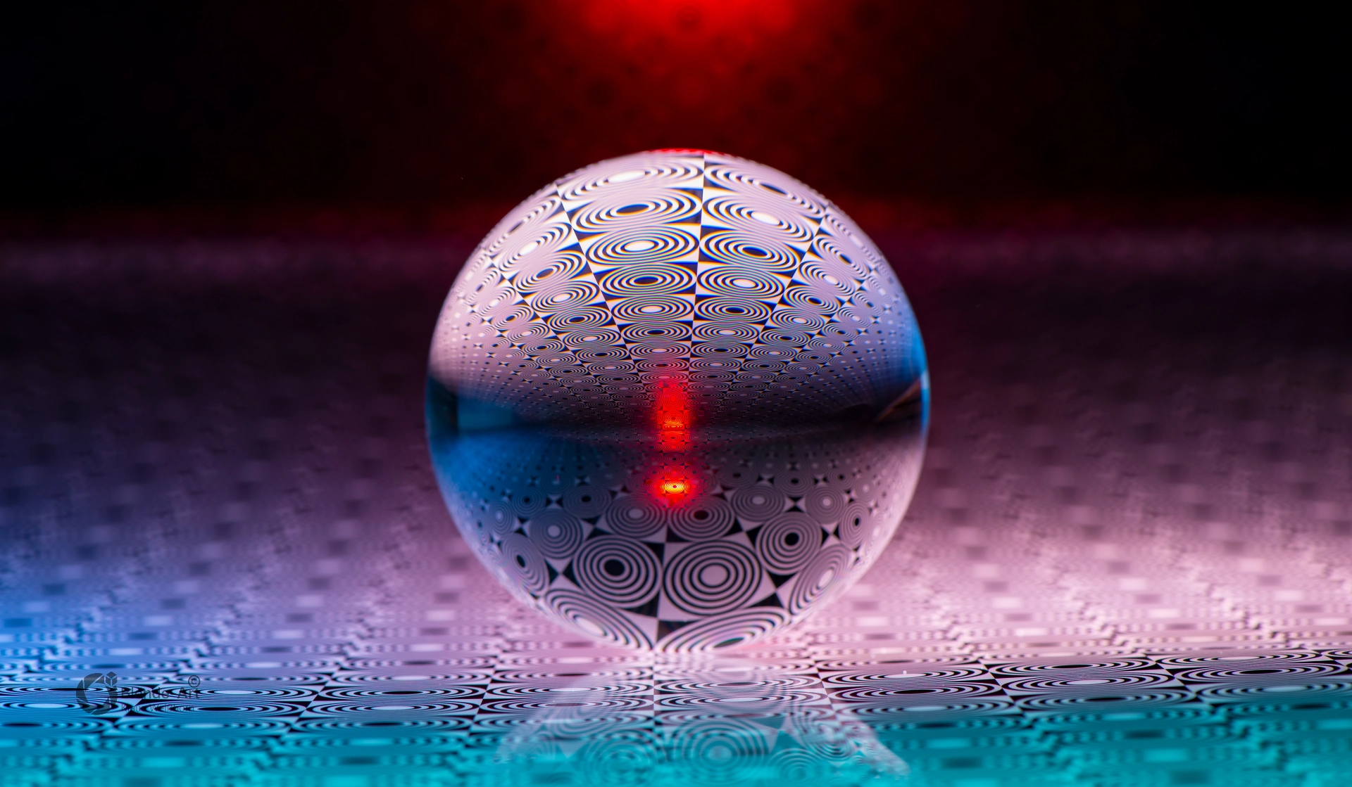 Glaskugel mit Punktmuster vor dunklem Hintergrund, durchzogen von einem roten Lichtstrahl, der sich vertikal in der Kugel spiegelt