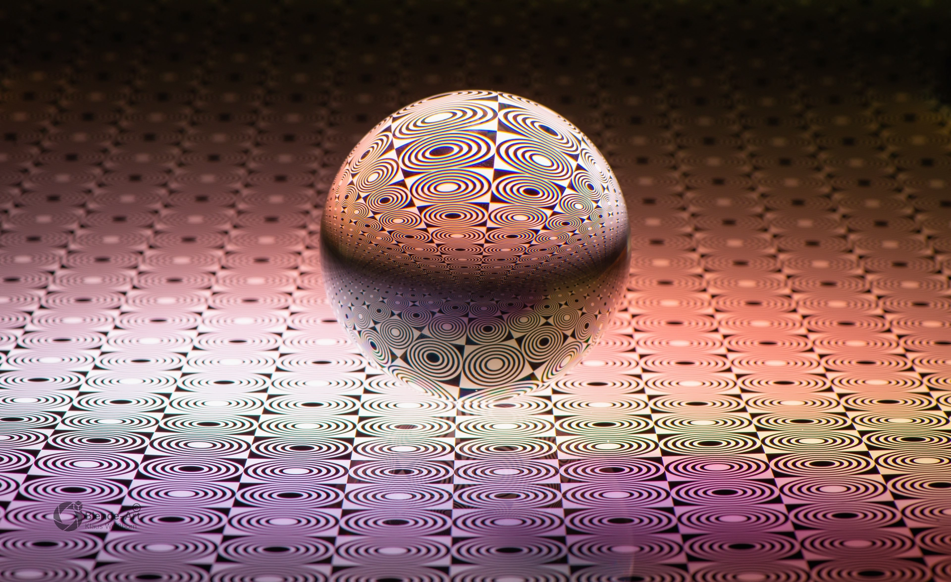 Glaskugel mit feinem Punktmuster auf warmem Farbverlauf in Rosa und Braun, das durch Lichtbrechung weich verzerrt wird