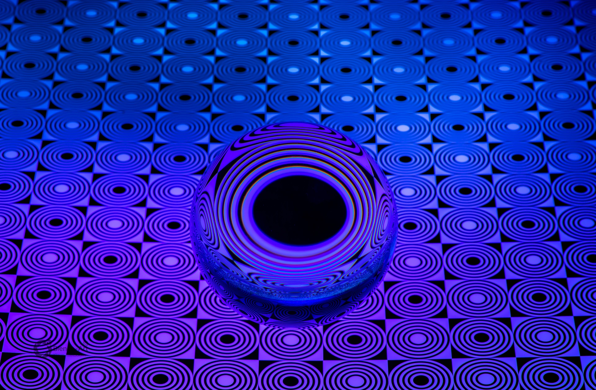 Glaskugel von oben mit blau-violettem Farbverlauf und sternförmigem Muster, das durch Lichtbrechung ein zentrales dunkles schwarzes Loch bildet
