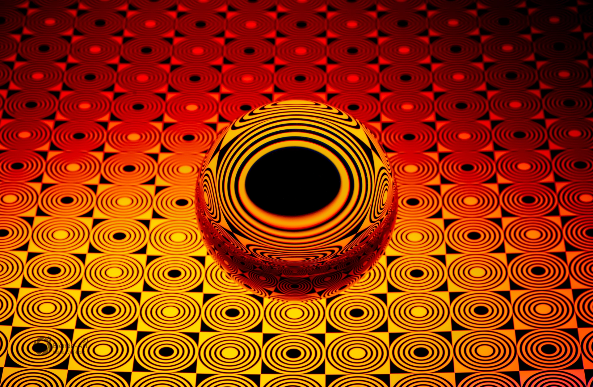 Glaskugel von oben mit warmem Farbverlauf in Gelb und Rot, zeigt ein sternförmiges Muster durch Lichtbrechung