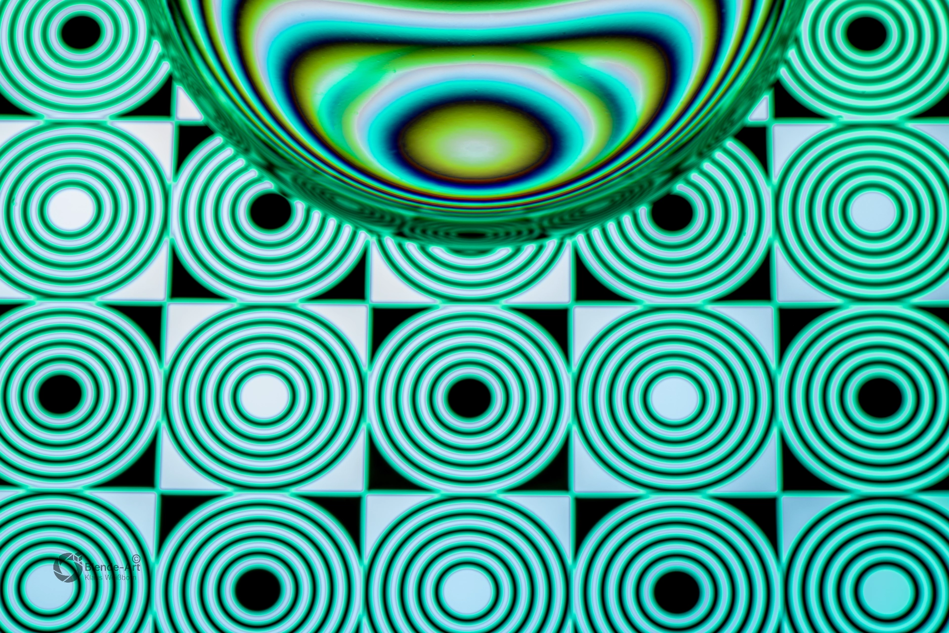 Glaskugel mit türkisfarbenem Muster aus konzentrischen Kreisen und geometrischen Formen, die durch Lichtbrechung verzerrt werden