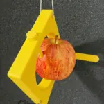 3D-gedruckter Apfelspieß für Vögel mit eingesetztem Apfel und integrierter Sitzstange zum Aufhängen.