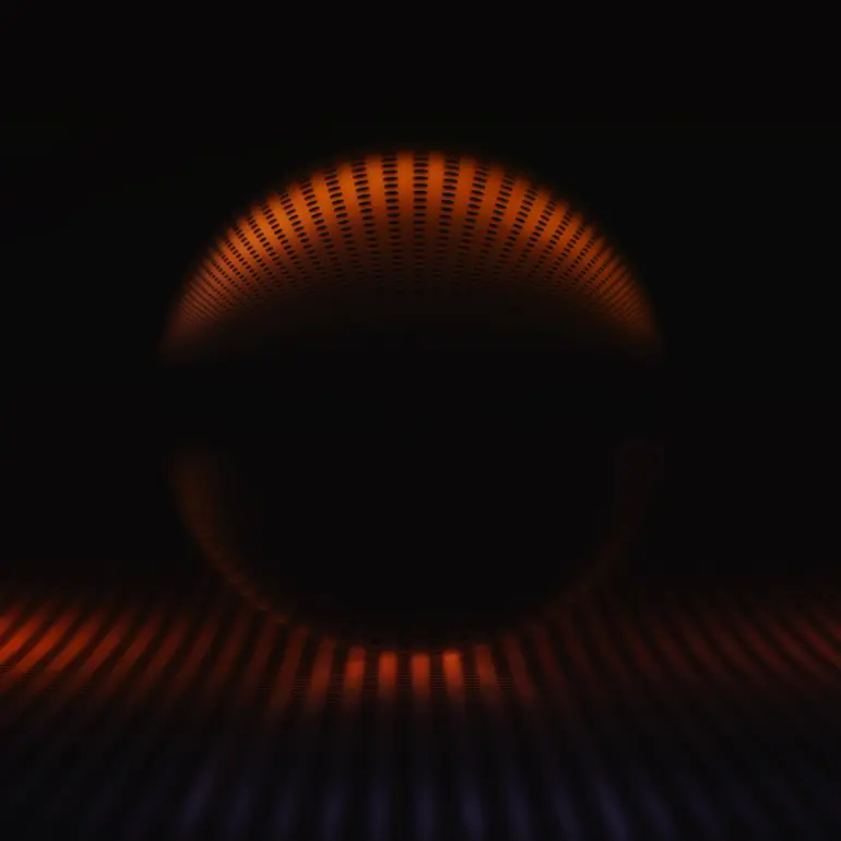 Glaskugel Fotografie mit orangen Lichtraster und dunklem Lichtakzent auf schwarzem Hintergrund