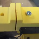 Gelbe 3D-gedruckte Sägehilfe mit fixiertem 30-mm-Aluminiumprofil, Befestigungsschraube und Sägeführung