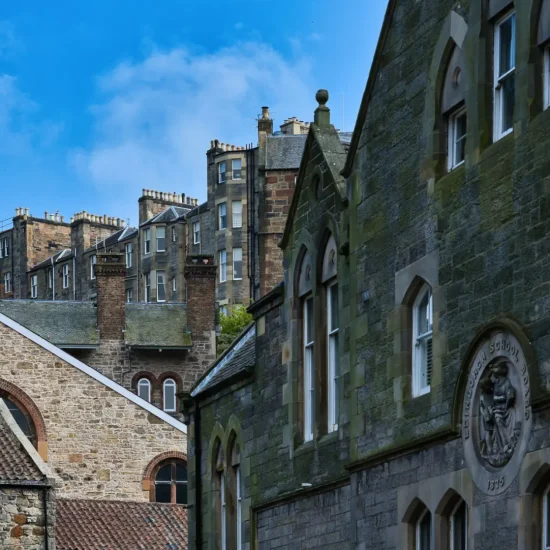 Historische Steinbauten in Edinburgh mit „Edinburgh School Board“-Relief von 1873 und Altstadthäusern im Hintergrund.